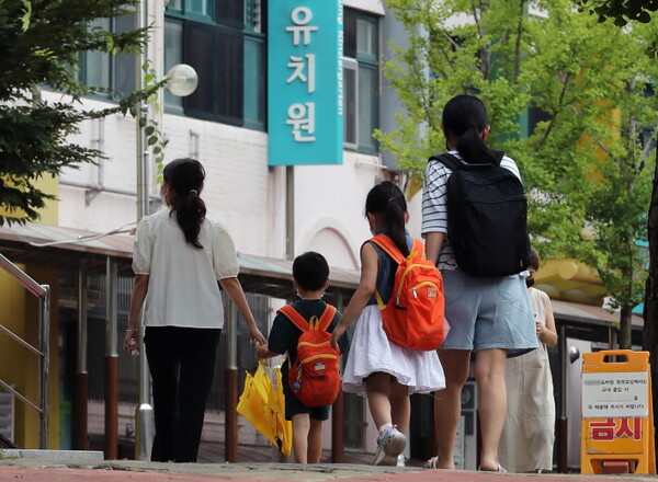2일 오전 서울 중구 한 유치원 앞에서 보호자가 자녀와 함께 등원하고 있다.