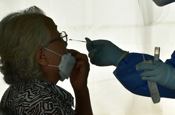 22일 오전 대구 중구 국채보상운동기념공원에 마련된 코로나19 임시선별검사소에서 한 시민이 PCR 검사를 받고 있다.