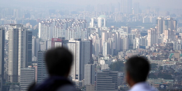 서울 용산구 남산에서 시민들이 아파트 등 주택이 밀집한 도심을 바라보고 있다.