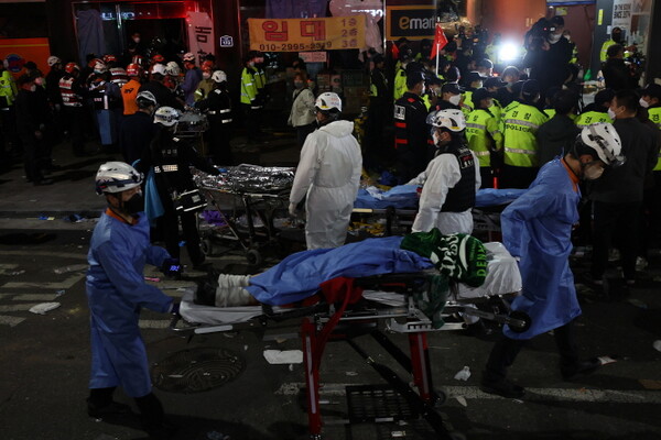 지난 29일 밤 서울 용산구 이태원 일대에서 대규모 압사사고가 발생한 가운데 30일 새벽 구급대원이 시신을 이송하고 있다.