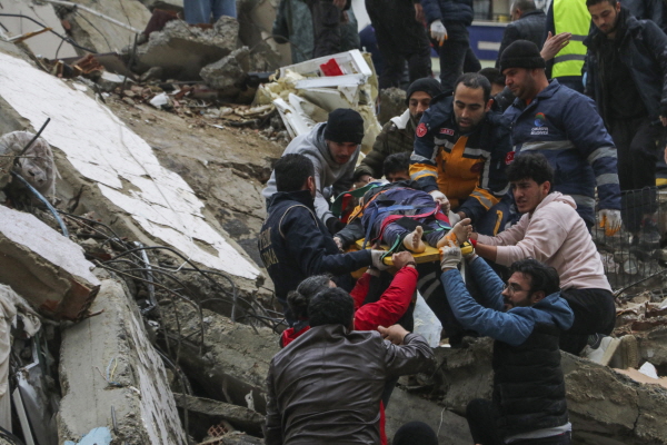 ​6일(현지시간) 튀르키예 남부에서 발생한 규모 7.8의 강진으로 아다나에서 구조대와 주민들이 무너진 건물 잔해에 있던 생존자를 구조해 옮기고 있다. 이번 지진으로 지금까지 튀르키예에서 최소 76명, 시리아에서 최소 99명이 숨진 것으로 나타났다.​