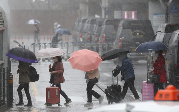 어린이날 황금연휴를 앞둔 4일 오전 제주국제공항 1층 도착장에 우산을 쓴 관광객들이 발걸음을 재촉하고 있다. 기상청에 따르면 오는 6일 오전까지 제주를 포함한 전국 대부분 지역에 강한 바람을 동반한 많은 비가 내릴 것으로 전망된다.