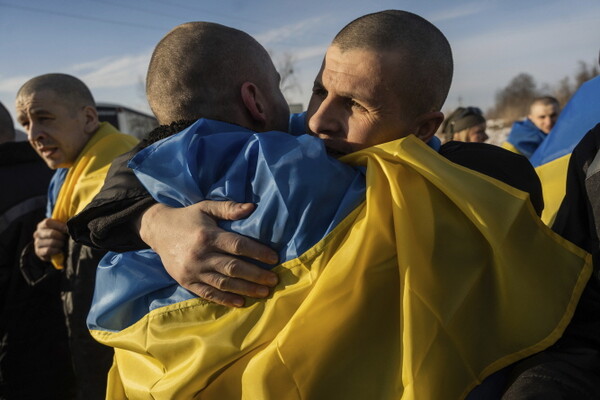 지난달 31일(현지시각) 우크라이나-러시아 국경 지역에서 포로 교환으로 풀려난 우크라이나 포로들이 국기를 몸에 두른 채 포옹하고 있다. 러시아와 우크라이나는 지난주 러시아의 우크라이나 포로 탑승 주장 수송기 추락으로 긴장이 고조됐음에도 포로 교환을 시행해 약 200명의 포로를 교환한 것으로 알려졌다.