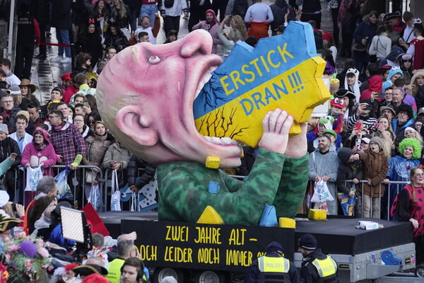 12일(현지시각) 독일 뒤셀도르프에서 전통 카니발 퍼레이드가 열려 블라디미르 푸틴 러시아 대통령이 우크라이나를 먹는 모습을 한 조형물이 행진하고 있다.